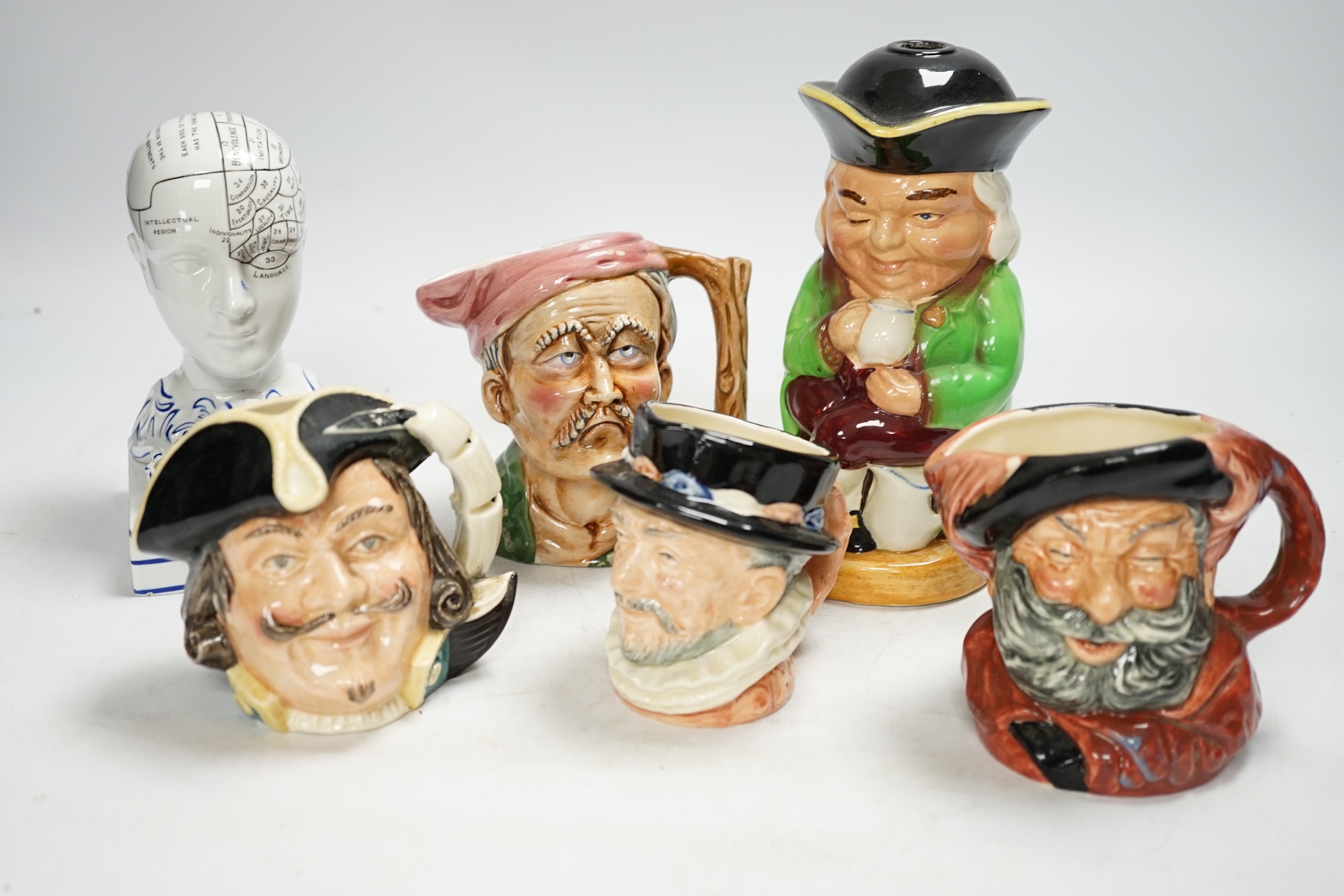 An F. Bridges Phrenology head inkstand, four Royal Doulton Toby jugs, two others, a phrenology bust and a framed pietra dura panel, tallest 17cm. Condition - poor to good, bust broken and re-glued